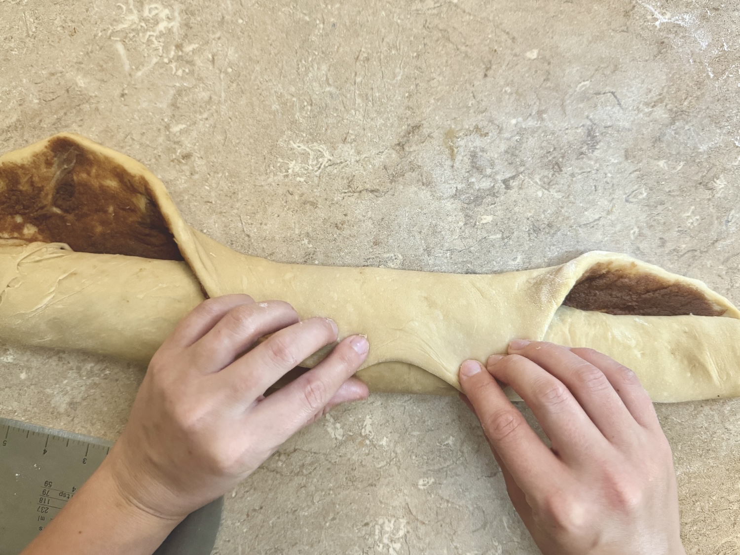 Rolling up cinnamon roll dough to be cut