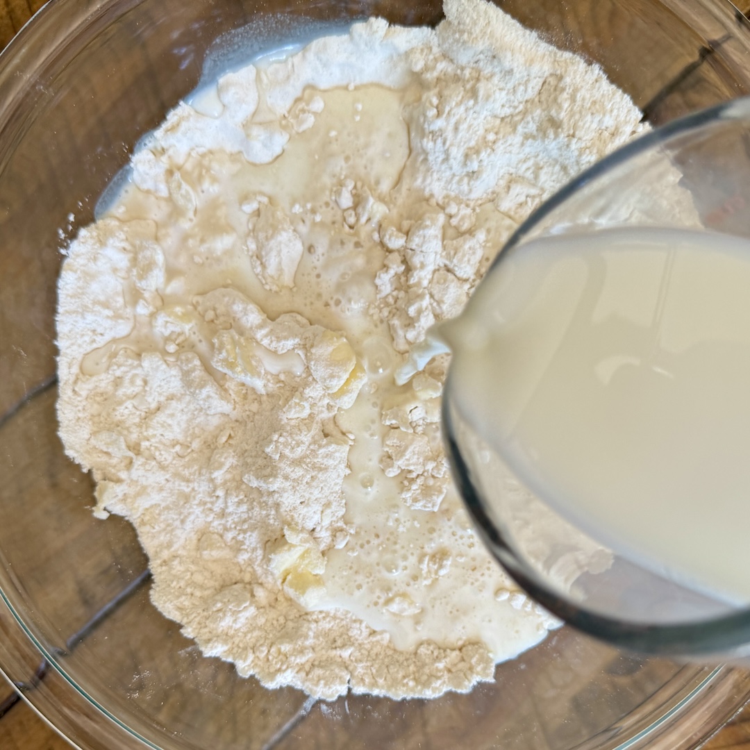 Adding milk to flour making biscuits