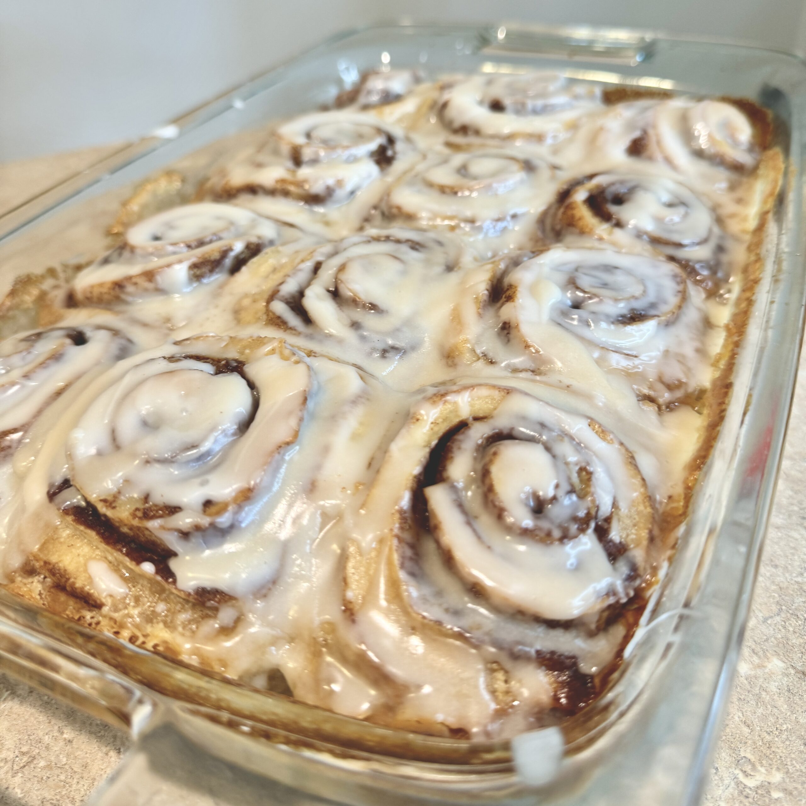 Close up shot of freshly baked iced cinnamon rolls