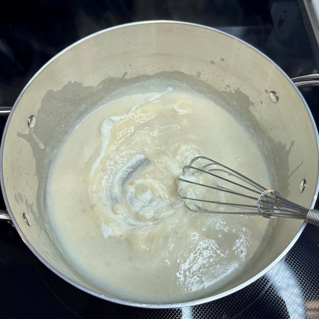 Whisking in greek yogurt to make cheese sauce