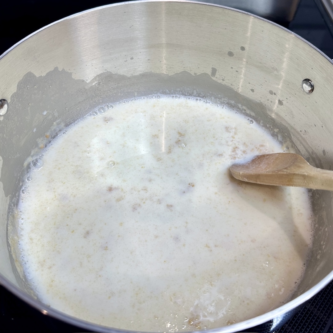 whisking in milk to the flour and butter roux