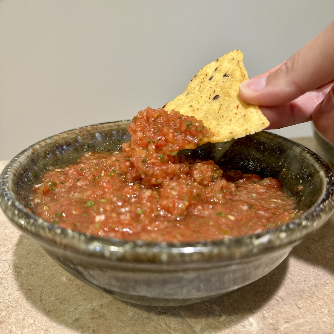 Chip dipped in fresh homemade salsa.