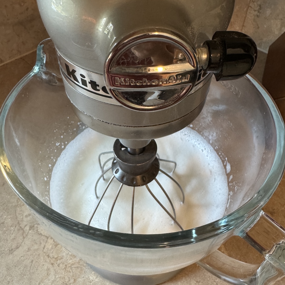 beating egg whites for tres leches cake in a stand mixer.