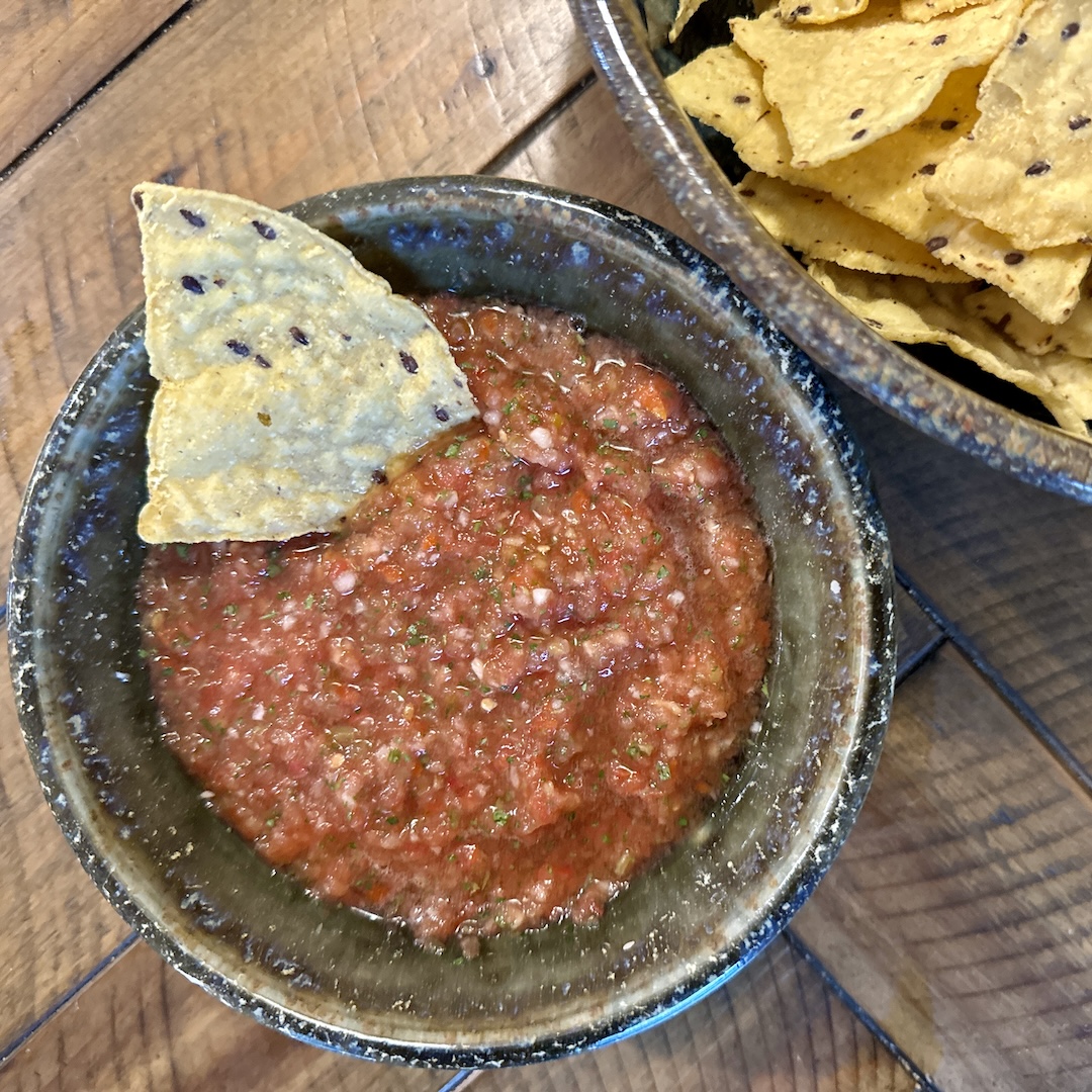 chip dipped in salsa bowl