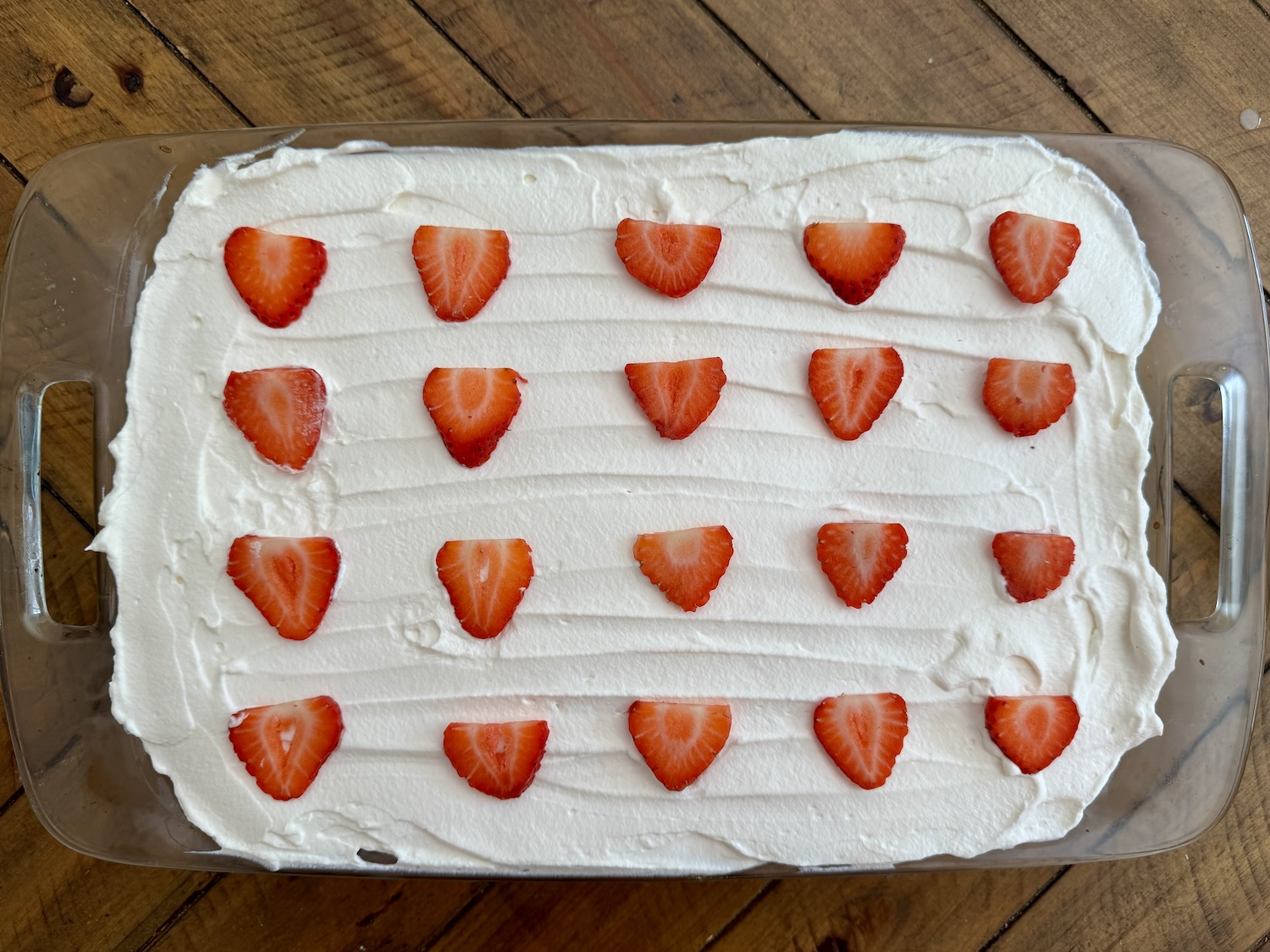 freshly made tres leche cake with strawberries on top