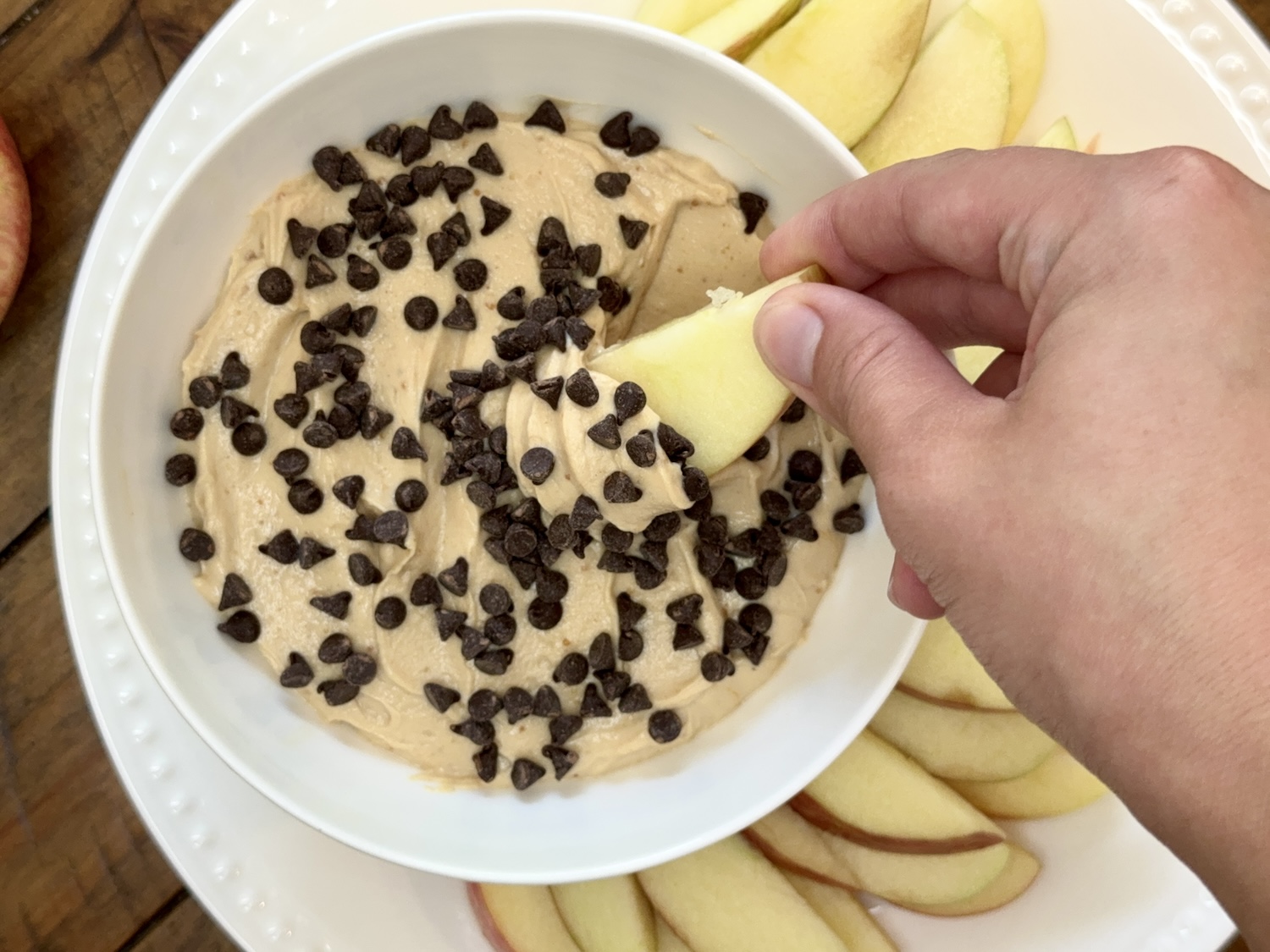 apple slice being dipped into high protein apple dips