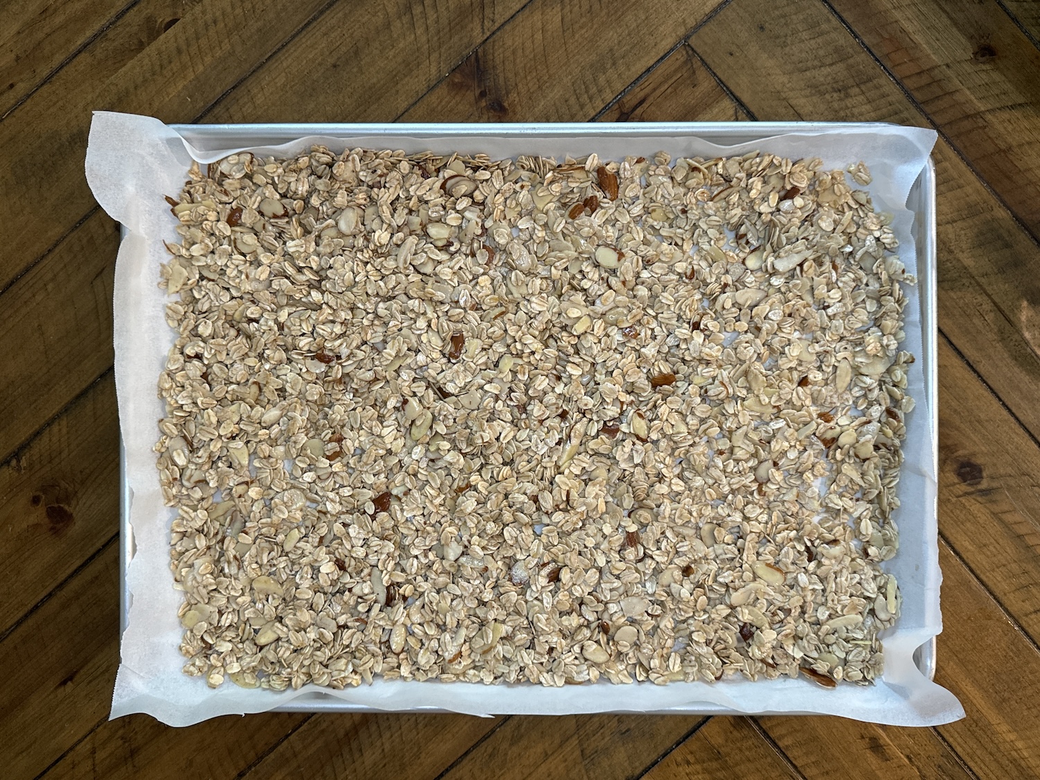 Oats, almonds, and spices ready to be baked to make granola