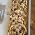 chocolate chip cookies stacked on baking sheet