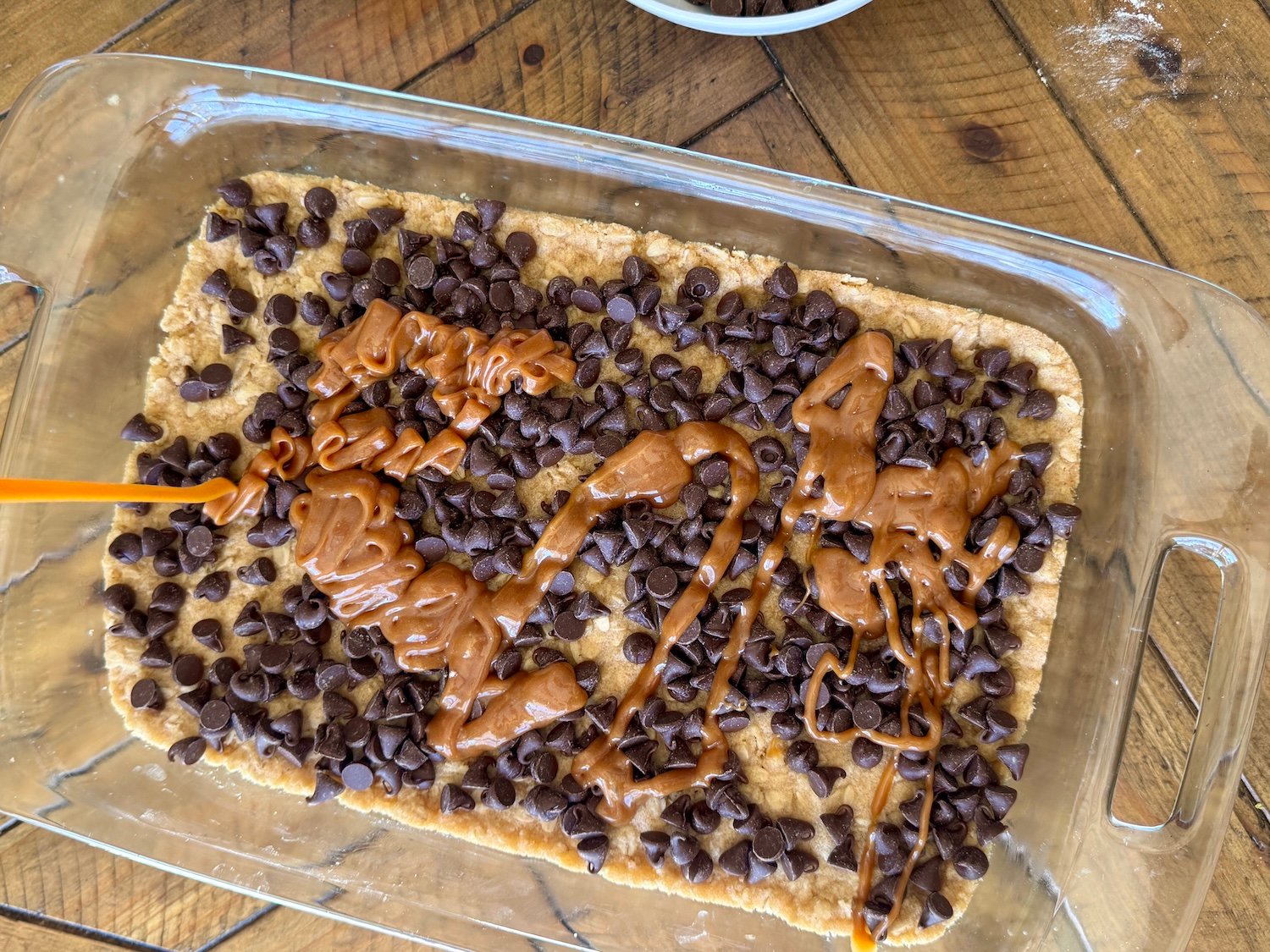 adding caramel sauce to carmelita bars