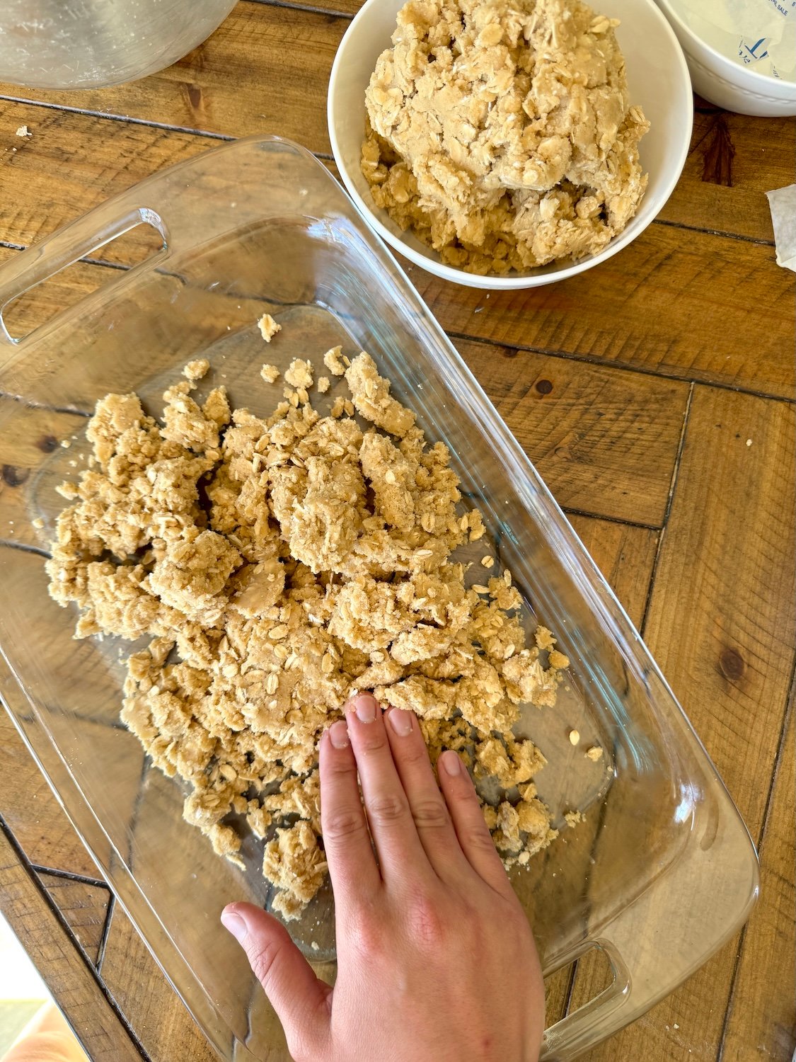 pressing oatmeal carmelita crust in baking dish